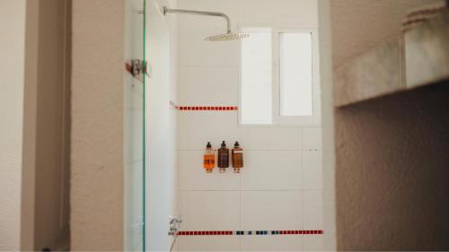 a bathroom with three bottles on the wall at La Mar de Bien in Buritaca