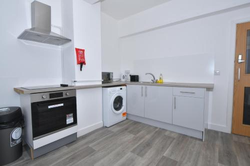 a white kitchen with a washing machine and a washer at Stay @ The Wellington, Burton On Trent in Burton upon Trent