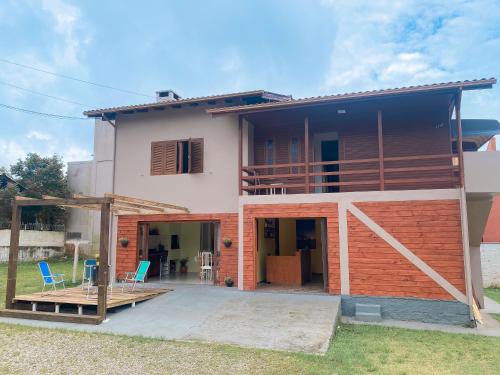 a house with a patio and two chairs at Picco da Ilha Hostel in Florianópolis