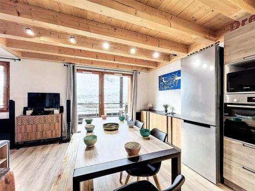 Il dispose d'une cuisine et d'un salon avec une table et un réfrigérateur. dans l'établissement Résidence Pistes - APPARTEMENT DUPLEX 4 PIECES 8/10 PERSONNES MAE-9304, au Corbier