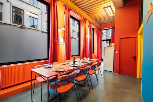 - une rangée de tables et de chaises dans une pièce aux murs orange dans l'établissement SmartStay Bird Family - X Rousse, à Lyon