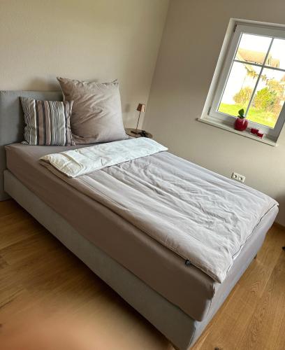 a large bed in a bedroom with a window at Haus am Mühlbach in Burgkirchen an der Alz