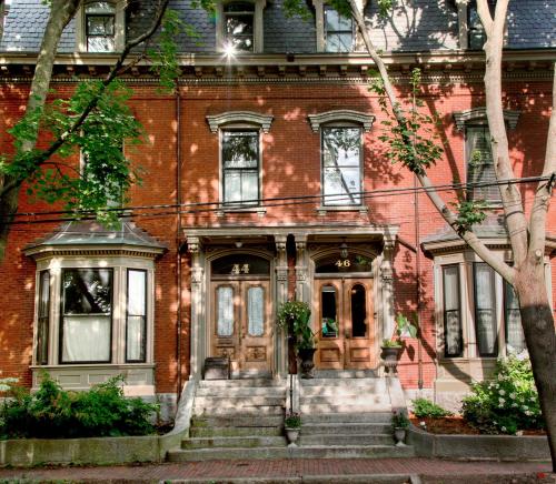 a red brick house with a front door and stairs at Blind Tiger Portland - Carleton Street Guest House in Portland