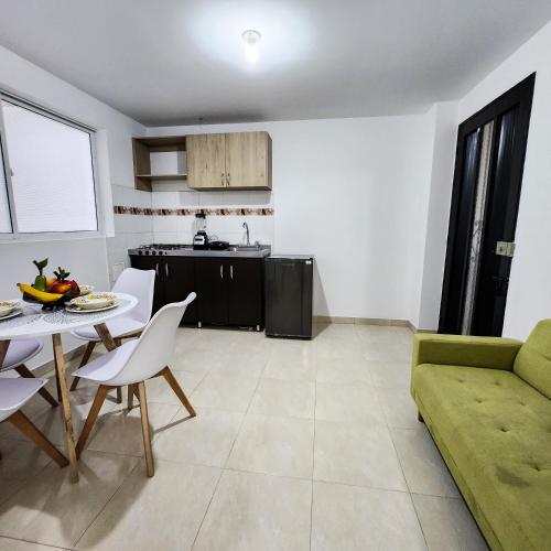 a living room with a table and a green couch at Apartamento Centro Comercial Campanario in Popayan