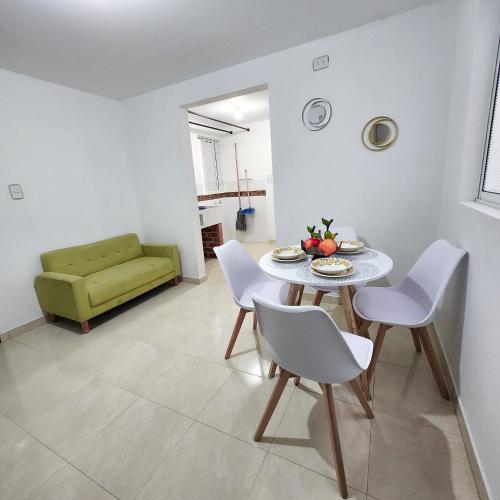 a living room with a table and chairs and a green couch at Apartamento Centro Comercial Campanario in Popayan