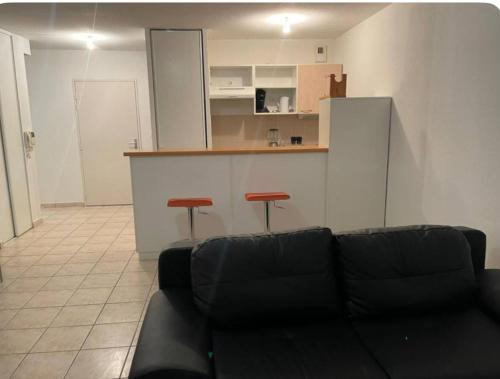 Una sala de estar con un sofá y una cocina. en La Pause Larzac-Parking privé-A 20 min de Millau, en La Cavalerie