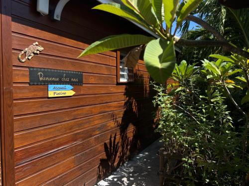a sign for a garden bar on a wooden fence at Domaine Racines e Zel - Gîte PomKajou in Vieux-Fort