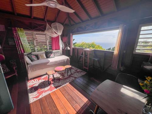 a room with a bed and a table and a window at Domaine Racines e Zel - Gîte PomKajou in Vieux-Fort
