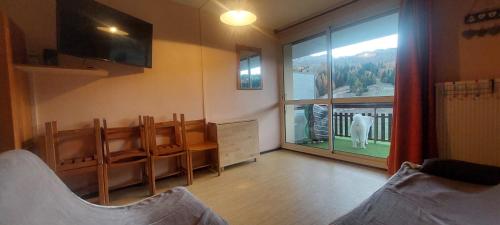 a living room with a large window with a dog outside at Superdevoluy Le bois d'aurouze in Superdevoluy