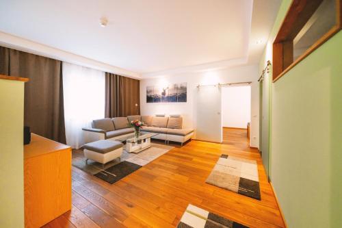 a living room with a couch and a table at Aktivhotel Wildschütz in Gmunden