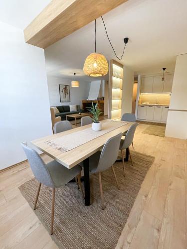 Un comedor y una sala de estar con mesa y sillas. en Lux Snowflake Poljice Jahorina, en Jahorina