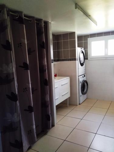 a small kitchen with a washing machine and a washer at Chambre spacieuse agréable fonctionnelle avec acces au wifi in Lesparre-Médoc