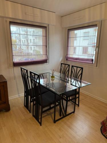 une salle à manger avec une table et des chaises en verre dans l'établissement 4 personnes 50 m2 Idéalement Situé à Strasbourg, à Strasbourg