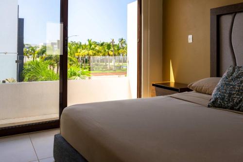 une chambre avec un lit et une grande fenêtre dans l'établissement Modern House 3 Bedrooms & Pool Acapulco, à Acapulco