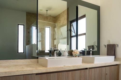 une salle de bain avec deux lavabos et un grand miroir dans l'établissement Modern House 3 Bedrooms & Pool Acapulco, à Acapulco