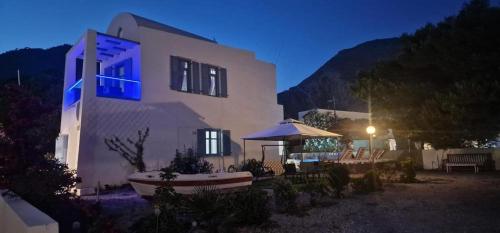 a building with a gazebo in front of it at night at Located by the sea one beachfront Private Captain Lazaros Pool Villa with loft in 750sqm spacious private plot-Jacuzzi-sunrelax-furnished terace-gazebo-private parking,sleep 3 adults and 2 children, just steps from the Black Beach-Seaview in Perissa