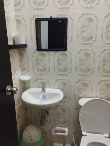 a bathroom with a sink and a toilet and a tv on the wall at Hotel Casa Real Málaga Santander in Málaga