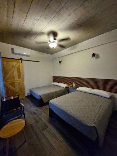 トゥストラ・グティエレスにあるinbed Hotelのベッド2台と天井ファンのある部屋