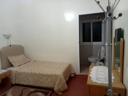 a small bedroom with a bed and a toilet at Maison d'hôtes afoulki tafraout in Tafraoute