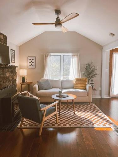 a living room with a couch and a table at Creek Side Cabin with Wood Fired Hot Tub and Fire Pit in New Milford
