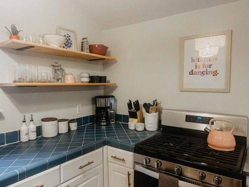 a kitchen with a stove and a blue tiled counter top at Creek Side Cabin with Wood Fired Hot Tub and Fire Pit in New Milford