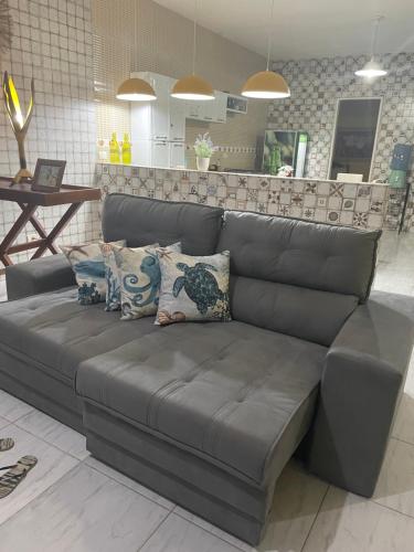 a gray couch with pillows on it in a room at Casa de Praia Tamandaré in Tamandaré