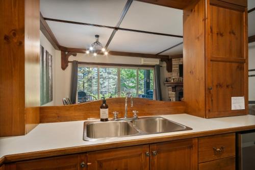 une cuisine avec un évier et une fenêtre dans l'établissement Les Manoirs by Rendez-Vous Mont-Tremblant, à Mont-Tremblant