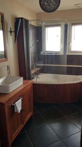 une salle de bain avec une baignoire et un lavabo dans l'établissement Maison, à Lombez