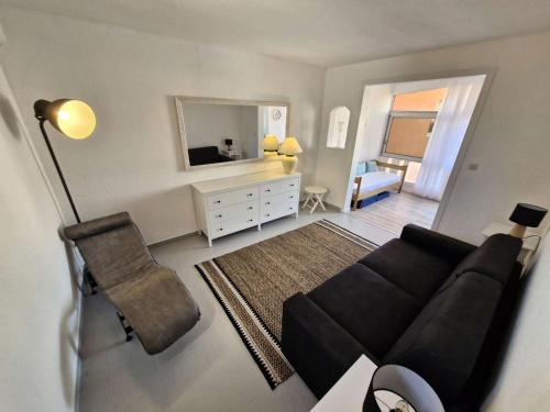 - un salon avec un canapé noir et un miroir dans l'établissement Résidence Nautica - Studio 3 personnes LE BARCARES. Réf: 9NAU11_23 MAE-9341, au Barcarès