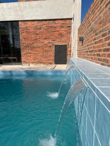 a water fountain in front of a brick building at Casa de verano en San Bernardino in San Bernardino