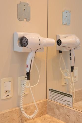 a white hairdryer on a wall in a room at Pousada Naala Gramado in Gramado