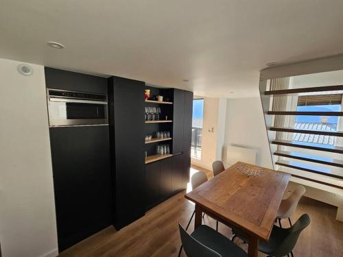 une salle à manger avec une table et des chaises en bois dans l'établissement Nouveau - Appartement premium entièrement rénové - 100m Alpe express - Retour ski aux pieds, à Huez