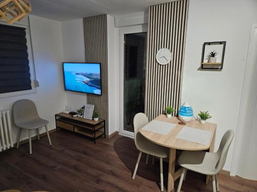 a living room with a dining room table and a tv at Modern Apartment S22 in Niš