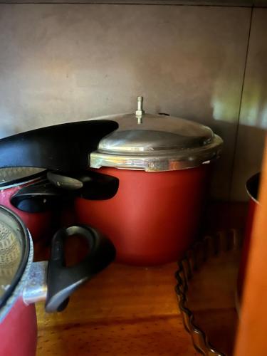 a red pot with a lid next to a pair of scissors at Casa de verano en San Bernardino in San Bernardino