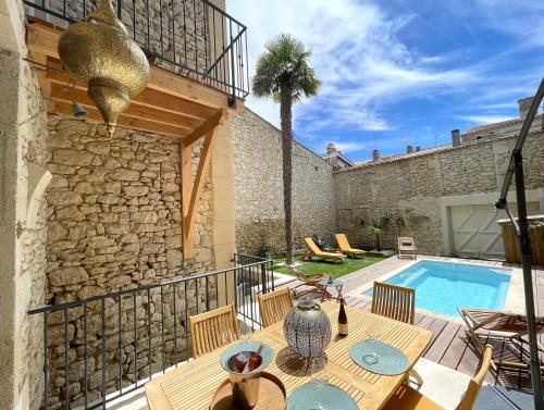 a patio with a table and a swimming pool at Villa Eleonore - Chic Central Retreat Heated Pool in Monségur