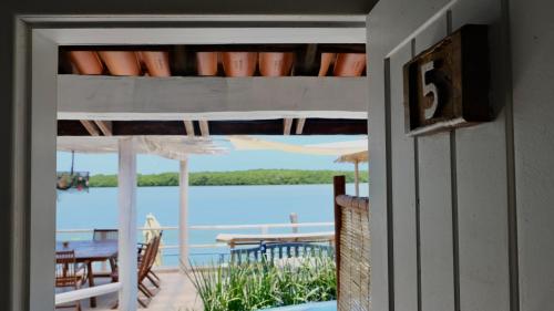 a door to a porch with a view of the water at Restaurante & Pousada Gaivota in Santo André