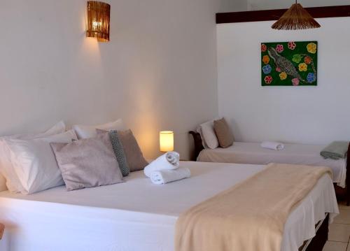 a bedroom with a large white bed with a stuffed animal on it at Restaurante & Pousada Gaivota in Santo André