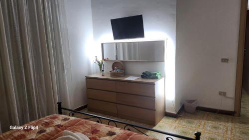 a bedroom with a dresser with a tv on top at B&b I DUE ANGELI in Quadrelle