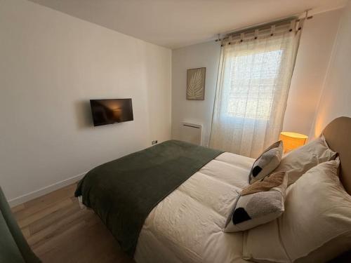 a bedroom with a large bed with a window at Appartement Cosy Cergy Le Haut Gare in Cergy