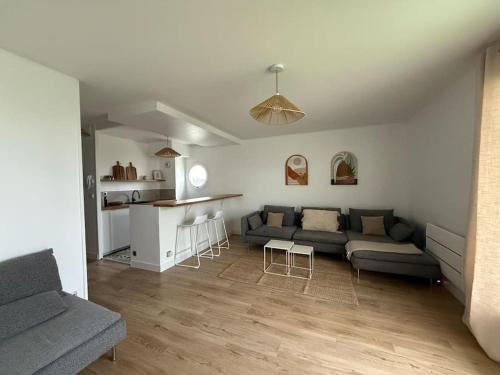 un salon avec un canapé et une cuisine dans l'établissement Appartement Cosy Cergy Le Haut Gare, à Cergy