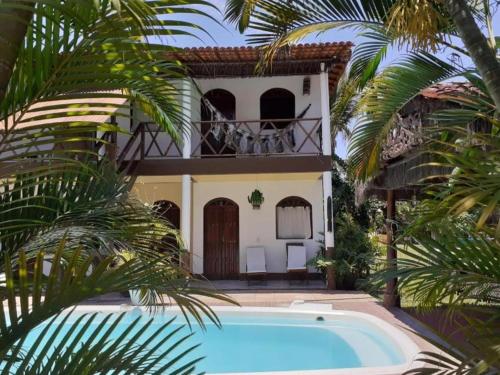 una villa con piscina di fronte a una casa di Pousada Paraíso do Mundo a Morro de São Paulo