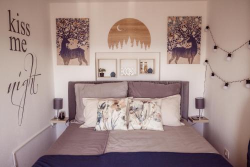 a bedroom with a bed with posters on the wall at LilMateHome in Harkány
