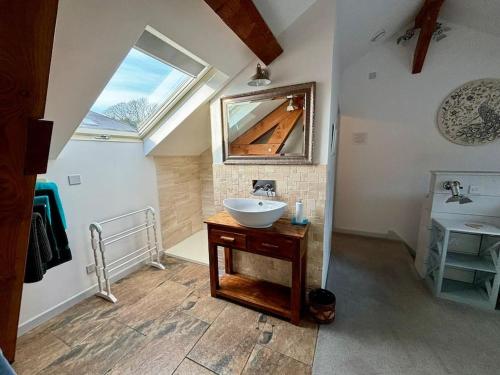 a bathroom with a sink and a mirror at Little Bream - pretty cosy cottage, sea views, walk to the beach in Mawnan Smith