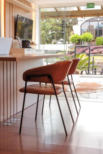 a chair sitting in front of a desk in a room at Pousada Naala Gramado in Gramado