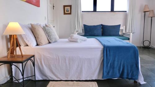 a bedroom with a bed with blue and white pillows at Restaurante & Pousada Gaivota in Santo André