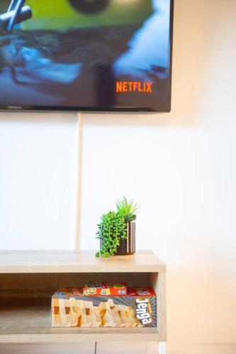 a tv sitting on top of a table with a plant at King Suite - Steps to Beach & Close to Pier in Oceanside