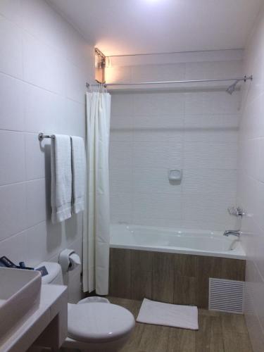 a bathroom with a tub and a toilet and a sink at Hotel Melodia in Lima