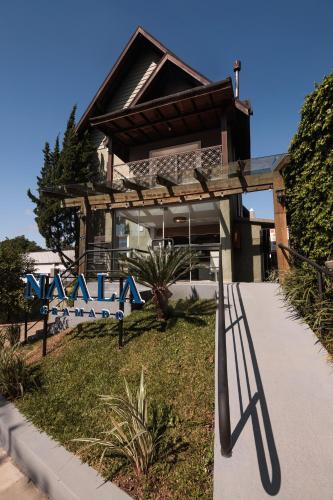 a building with a bench in front of it at Pousada Naala Gramado in Gramado