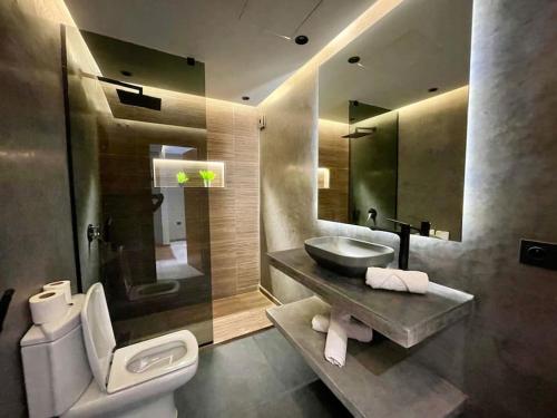 a bathroom with a sink and a toilet and a mirror at Golden Sand Apartment - Terrace & OceanView 2BD in Tangier
