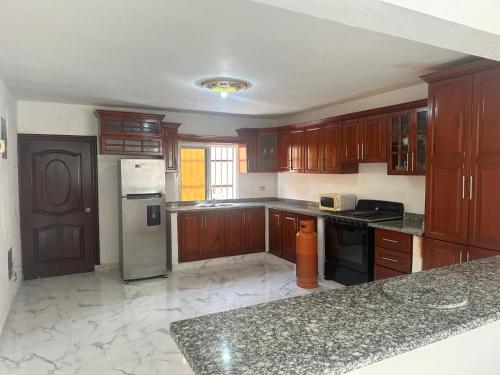 une grande cuisine avec des armoires et des appareils en bois dans l'établissement Casa las Américas, à La Alianza